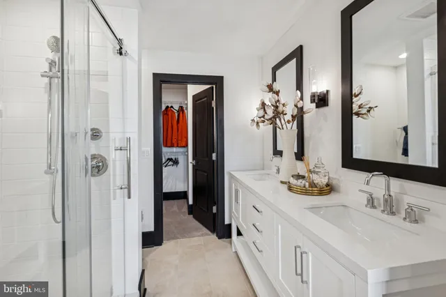 a en suite bathroom with a double vanity sink shower and a mirror