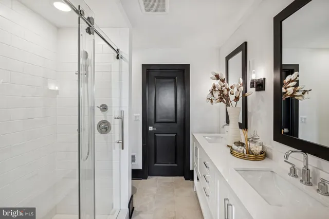 a bathroom with a double vanity sink a mirror and shower