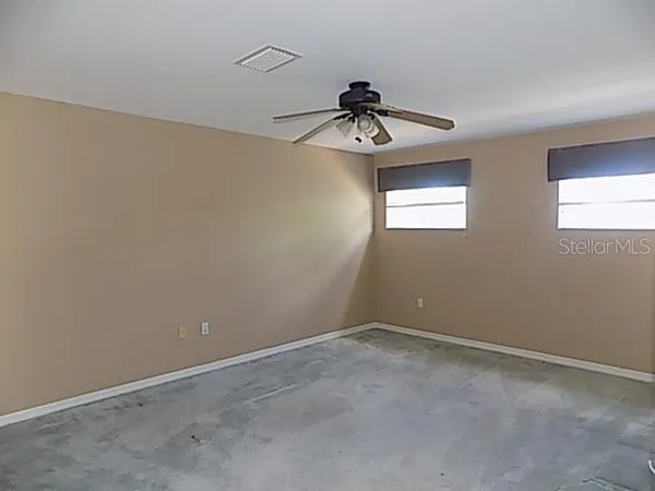 a view of a room with a ceiling fan and window