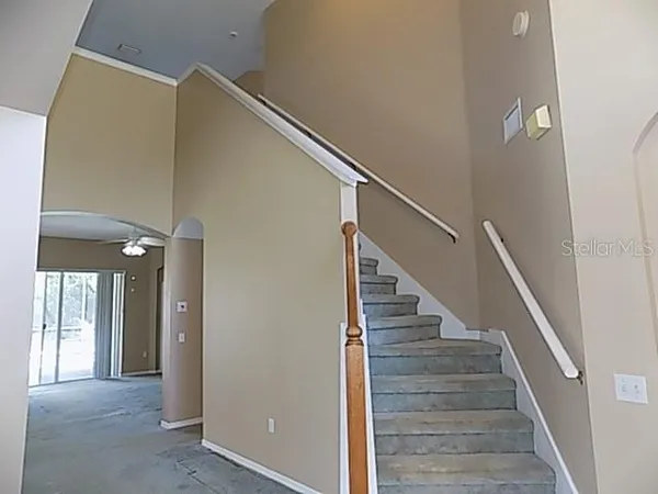 a view of hallway with stairs and wooden floor