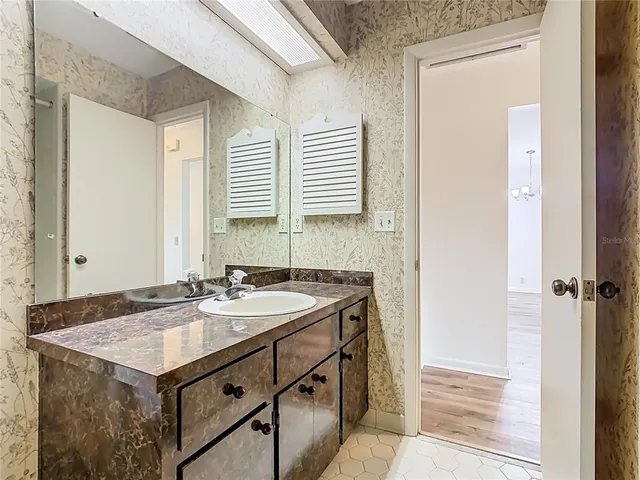 a bathroom with a granite countertop sink a toilet and a mirror