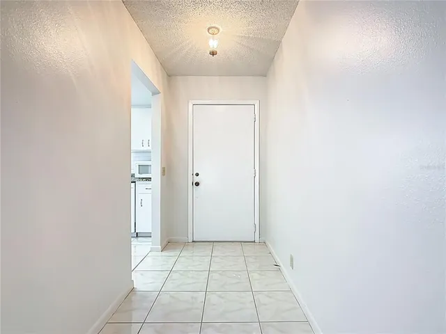 an empty room with white walls and tiles