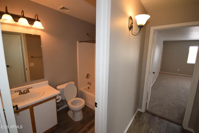 a bathroom with a granite countertop toilet and a sink