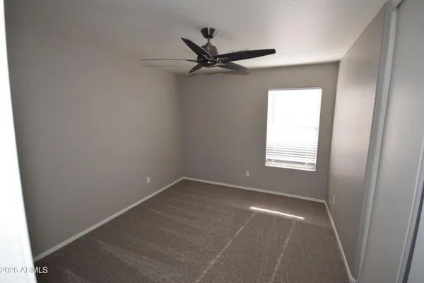 an empty room with a window and a fan