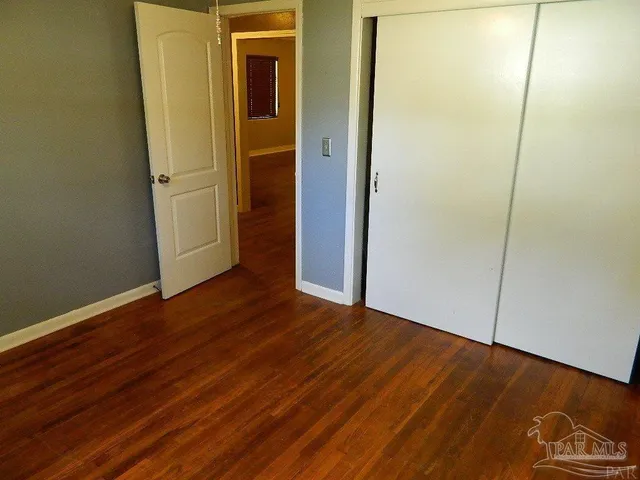 an empty room with wooden floor and closet