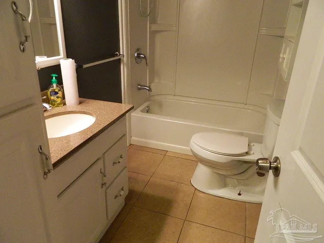 a bathroom with a granite countertop toilet sink and mirror