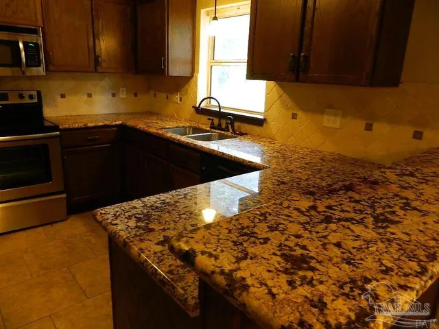 a kitchen with a sink a stove and cabinets
