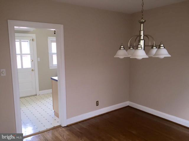 3014 Dunmurry Road Baltimore, MD 21222 - Photo 7 of 24 an empty room with wooden floor and windows