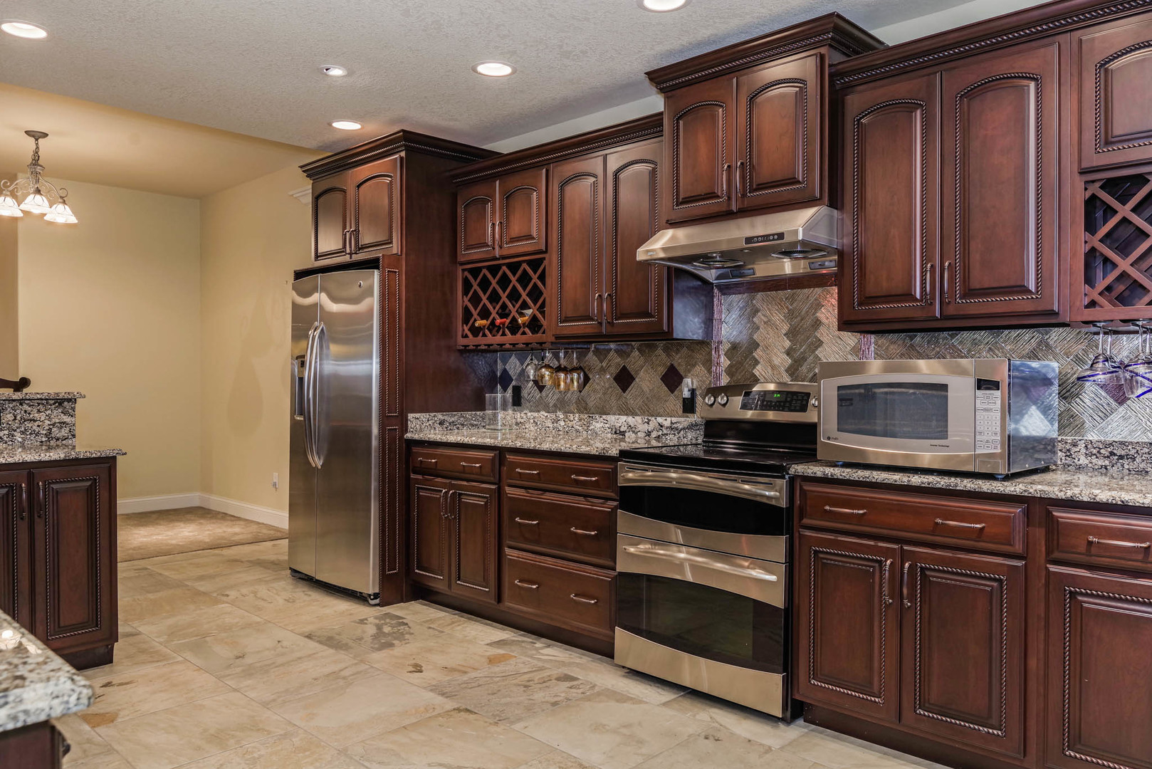 10470 Sturbridge Road Bloomington, IL 61705 - Photo 55 of 75 a kitchen with stainless steel appliances granite countertop a refrigerator and wooden cabinets