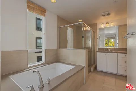 a bathroom with a granite countertop sink a large mirror and a shower