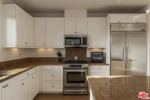a kitchen with kitchen island granite countertop a center island appliances and a counter top space