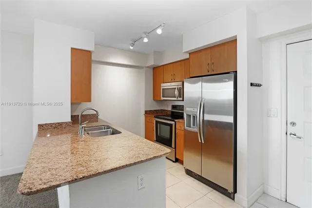 a kitchen with kitchen island a counter top space cabinets and stainless steel appliances