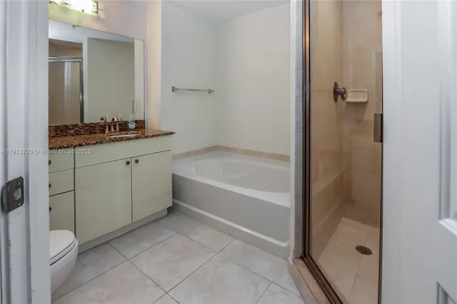 a bathroom with a granite countertop sink a mirror and a bathtub