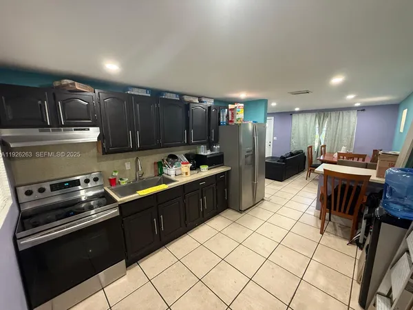 a kitchen with kitchen island granite countertop a stove sink and cabinets