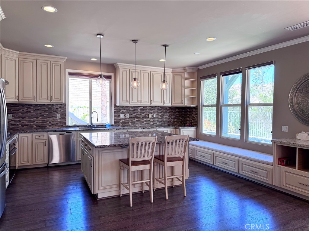 28463 Cascade Road Castaic, CA 91384 - Photo 8 of 29 a kitchen with granite countertop wooden floors white cabinets and appliances