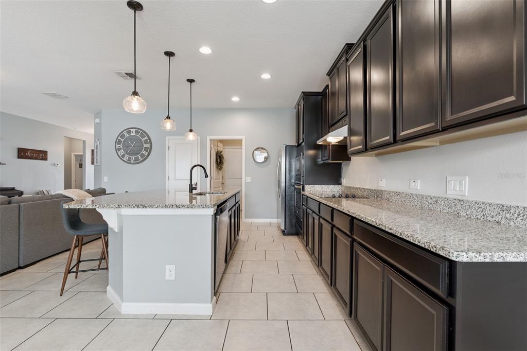 1725 Reflection Lane St. Cloud, FL 34771 - Photo 12 of 37 a large kitchen with stainless steel appliances granite countertop a sink a stove and a wooden floors