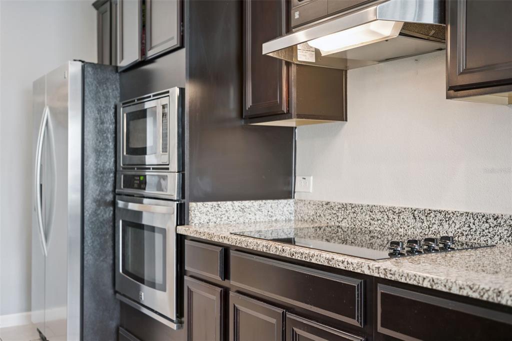 1725 Reflection Lane St. Cloud, FL 34771 - Photo 13 of 37 a kitchen with granite countertop stainless steel appliances and wooden cabinets