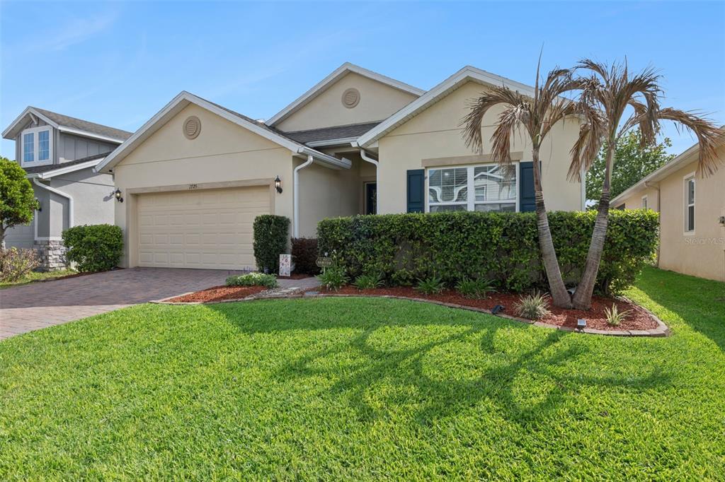 1725 Reflection Lane St. Cloud, FL 34771 - Photo 2 of 37 a front view of a house with a yard and garage