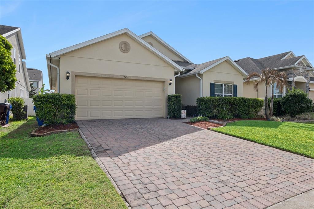 1725 Reflection Lane St. Cloud, FL 34771 - Photo 3 of 37 a front view of a house with a yard and garage