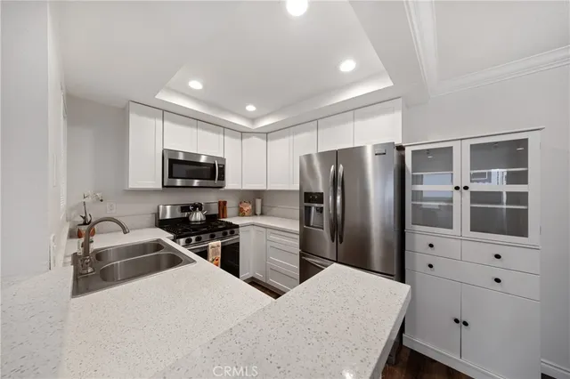 a kitchen that has a refrigerator a stove top oven a sink and dishwasher with wooden floor