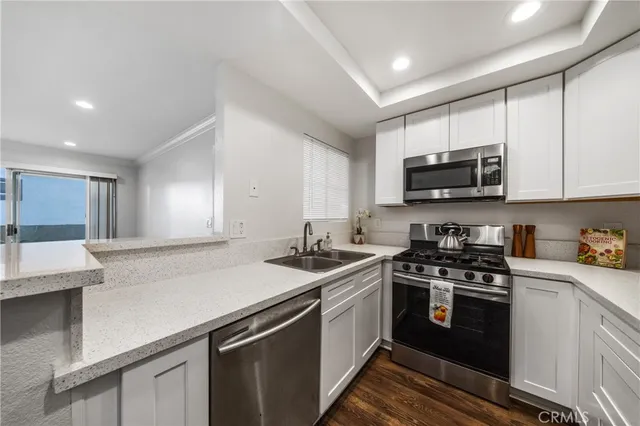 a kitchen with a sink a stove a microwave and cabinets