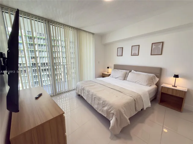 a spacious bedroom with a bed and a large window