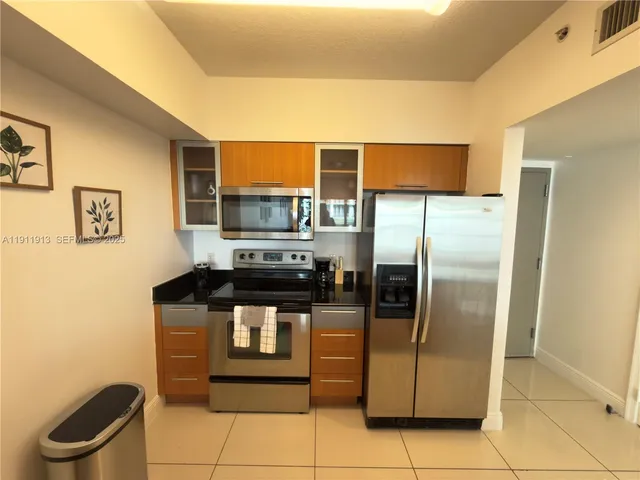 a kitchen with stainless steel appliances granite countertop a refrigerator a stove and a sink