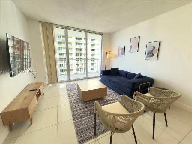 a living room with furniture and a floor to ceiling window