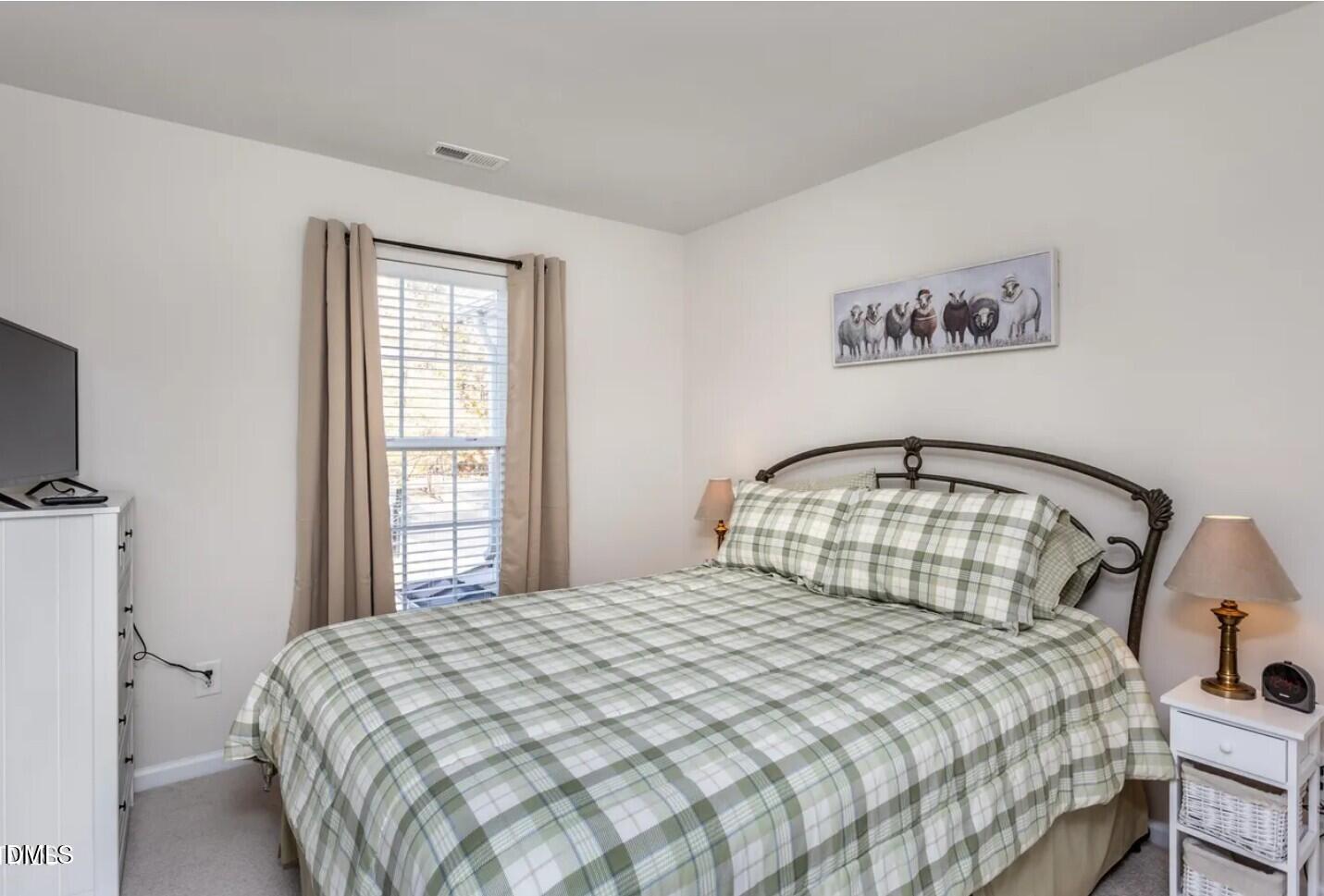 7031 Racine Way Raleigh, NC 27615 - Photo 21 of 24 a bedroom with a bed and a large window