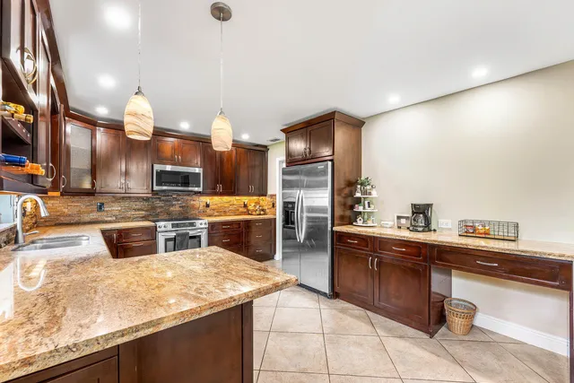 a kitchen with stainless steel appliances granite countertop a sink counter space cabinets and a stove