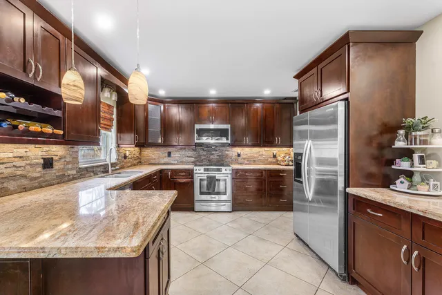 a kitchen with stainless steel appliances granite countertop a sink stove and refrigerator