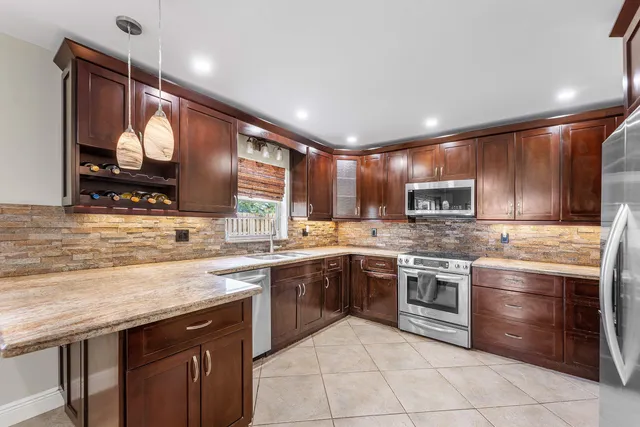 a kitchen with stainless steel appliances granite countertop a sink and stove top oven