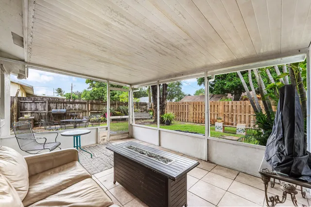 a view of a patio with a table chairs and a floor to ceiling window