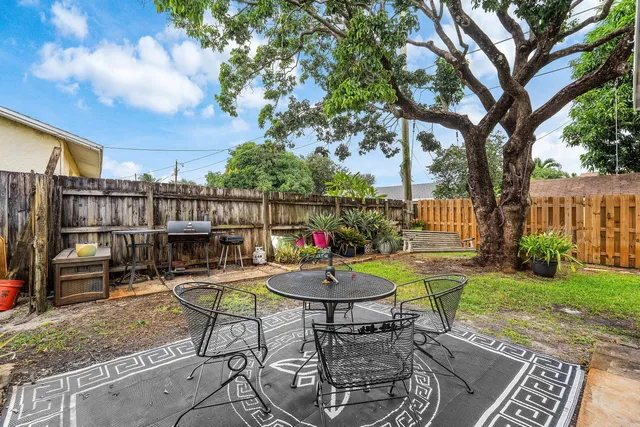 a view of a backyard with sitting area furniture and garden
