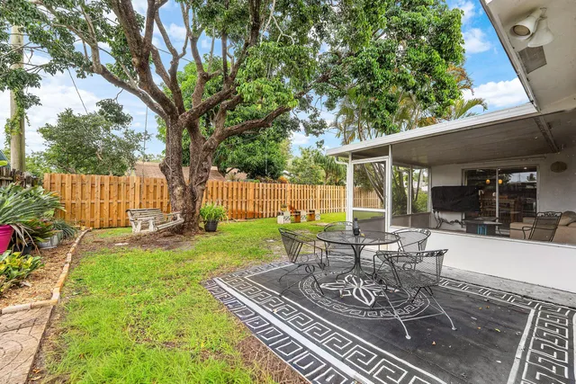 a view of a chair and table in backyard of the house