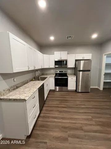 a large kitchen with stainless steel appliances granite countertop a stove a sink and a refrigerator