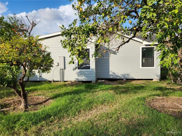 a white house that has tree in front of it