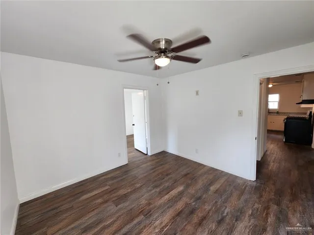a view of a livingroom with a ceiling fan wooden floor and a ceiling fan