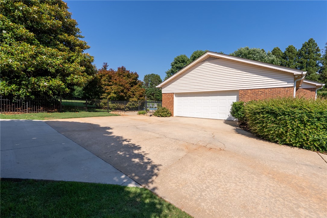 3513 Hopewell Road Anderson, SC 29621 - Photo 32 of 50 A classic brick and siding garage awaits with a spacious driveway and surrounding mature trees.