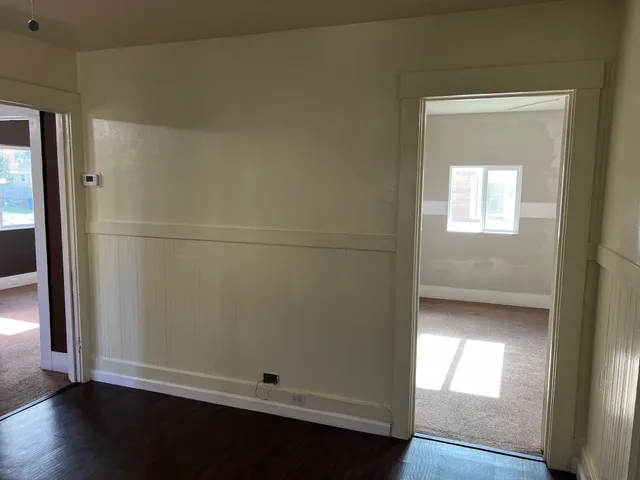 an empty room with wooden floor and a window