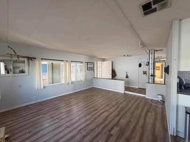 a view of a livingroom with wooden floor and a ceiling fan