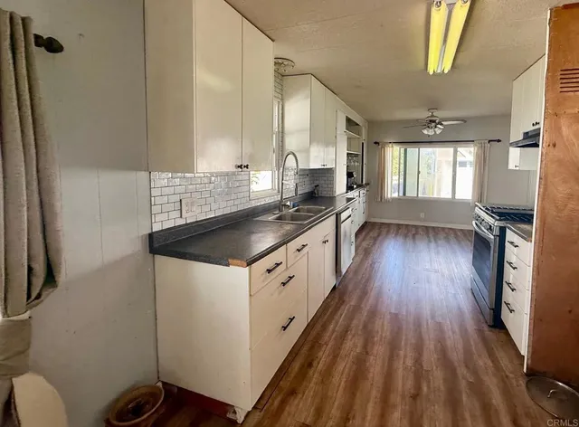 a view of a living room hardwood floor and a kitchen
