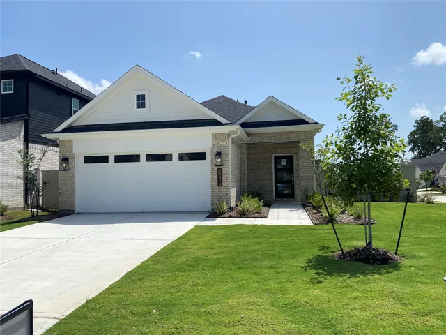 a front view of a house with a yard and trees