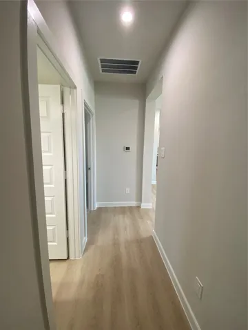 a view of a hallway with wooden floor