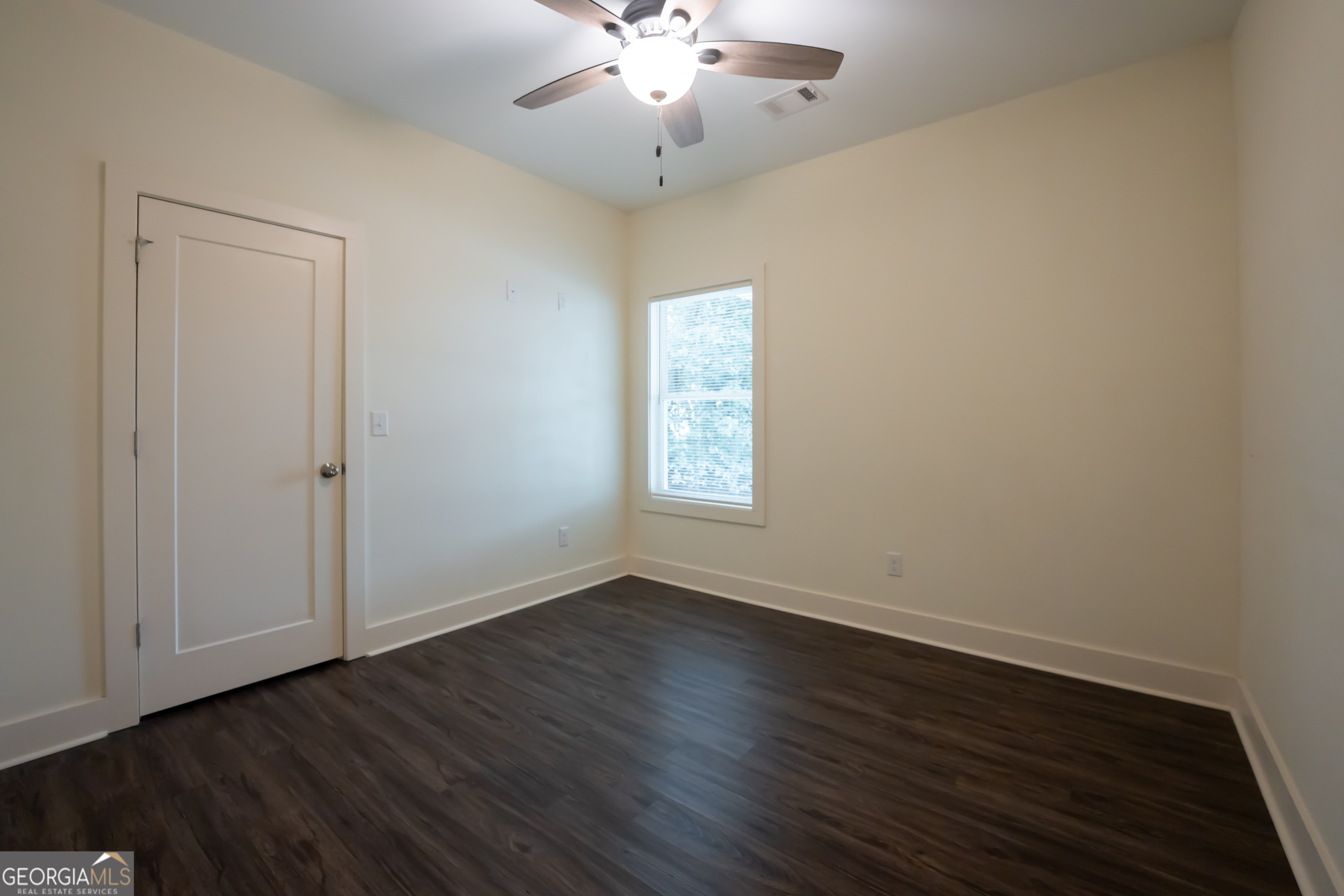 1000 Bell Circle Madison, GA 30650 - Photo 12 of 21 an empty room with wooden floor chandelier fan and windows