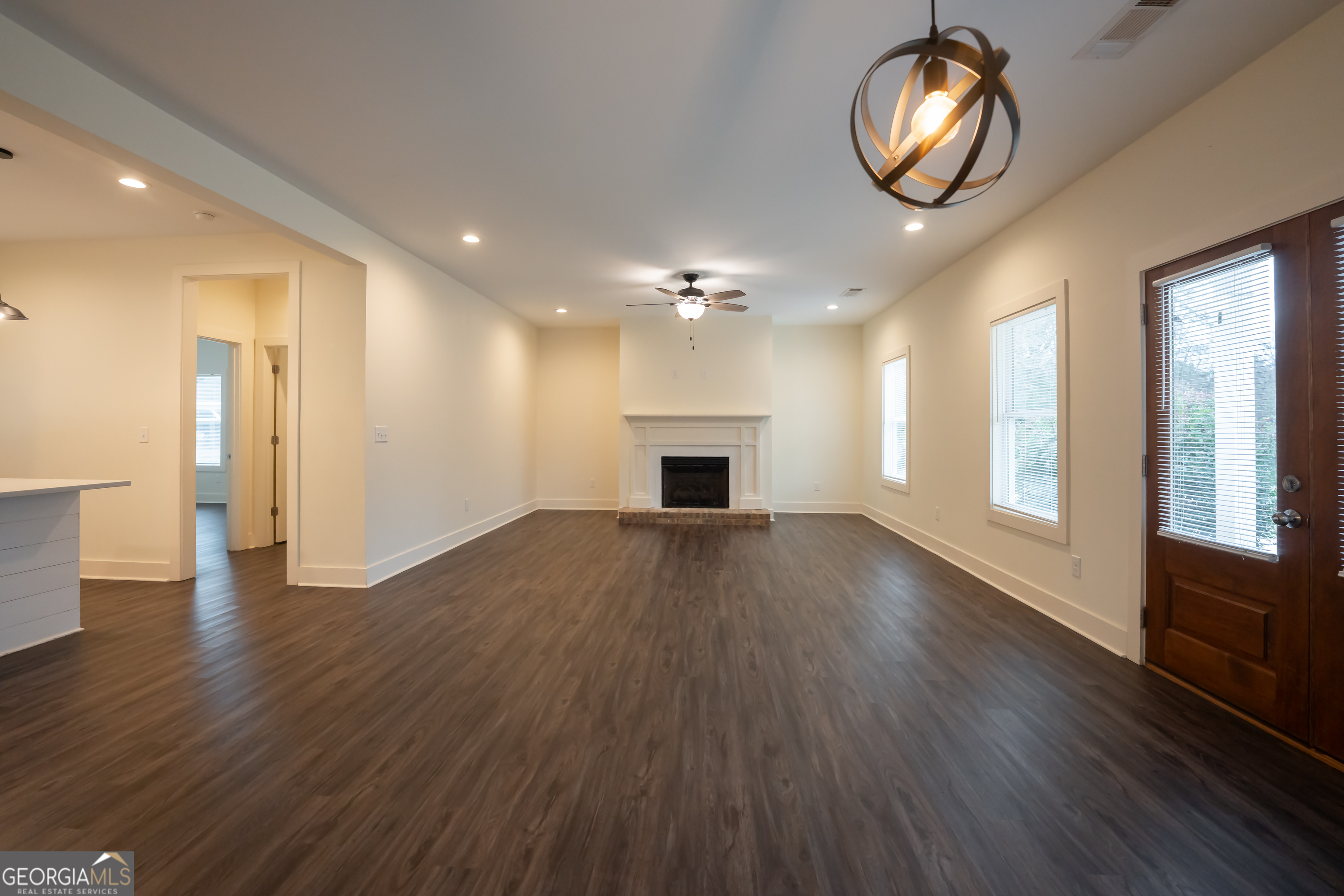 1000 Bell Circle Madison, GA 30650 - Photo 4 of 21 an empty room with wooden floor mirror and windows