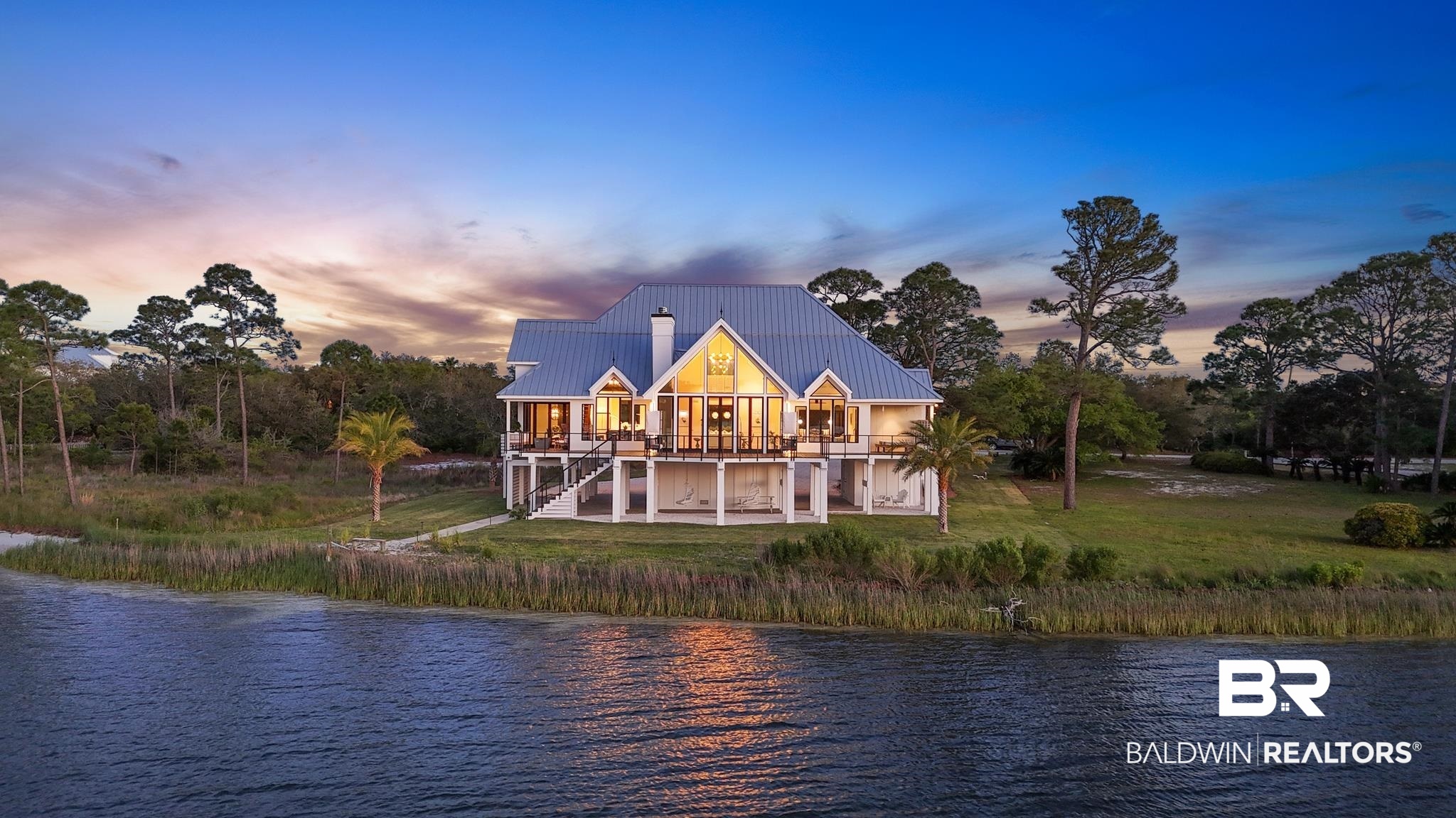 33349 River Road Orange Beach, AL 36561 - Photo 60 of 61 Waterfront residence featuring a metal roof, expansive deck, multiple French doors, large windows, and an elevated foundation