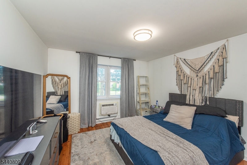 206 Main Street, Unit 42A Millburn, NJ 07041 - Photo 15 of 21 a bedroom with a bed and a flat screen tv