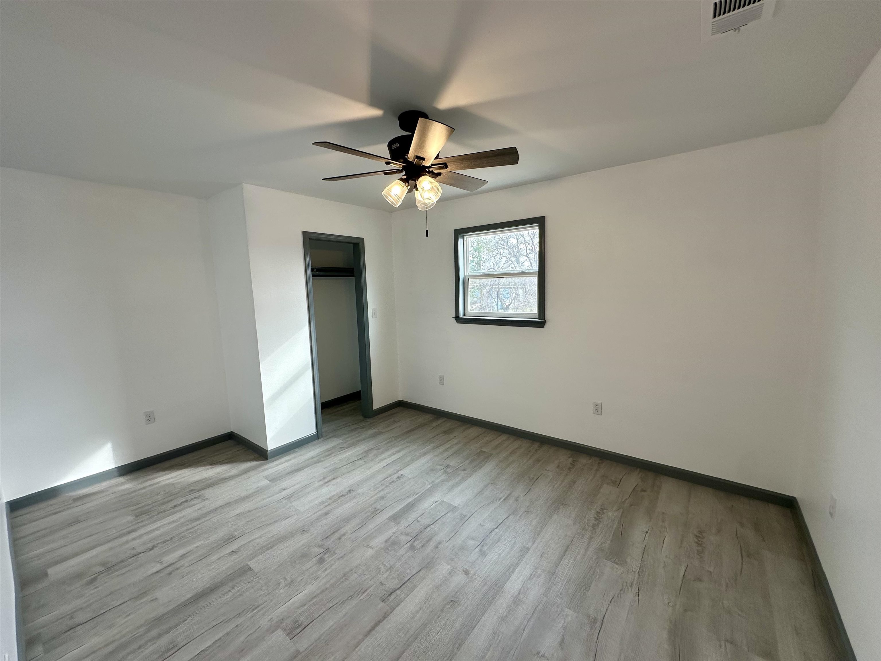 3410 Cactus Trail Kingsland, TX 78639 - Photo 13 of 26 an empty room with wooden floor chandelier fan and windows