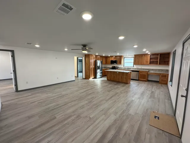 a view of a kitchen with kitchen island wooden floor and center island